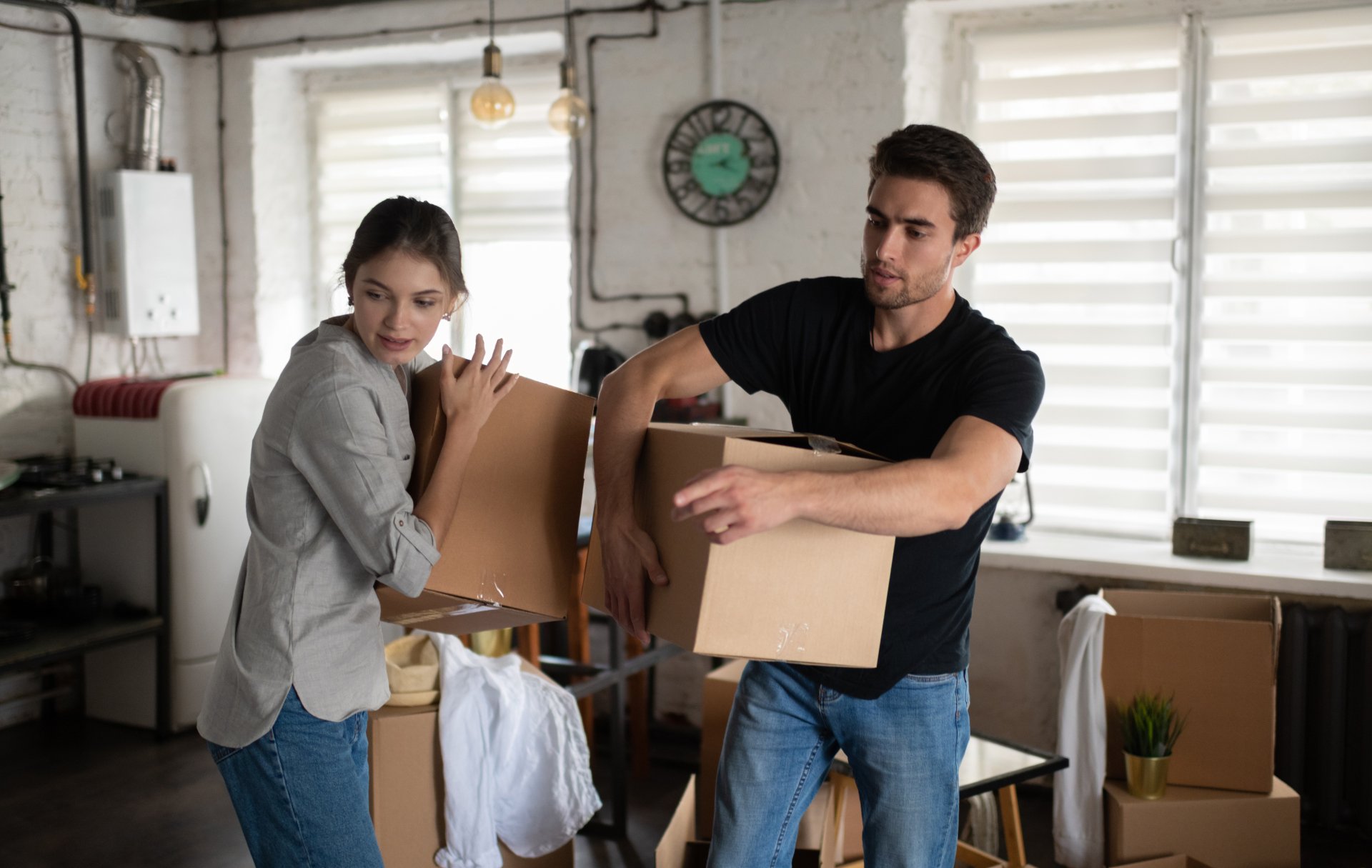 young-couple-carrying-carton-boxes-during-relocati-QFS6VTN